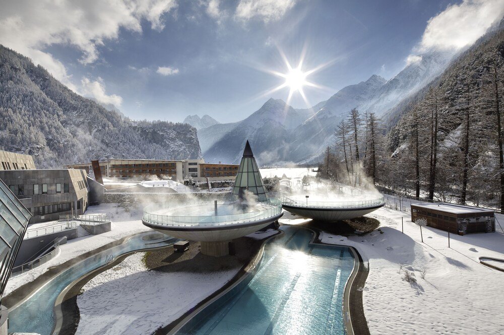Modern spa area with a hot tub and pool against a mountain backdrop