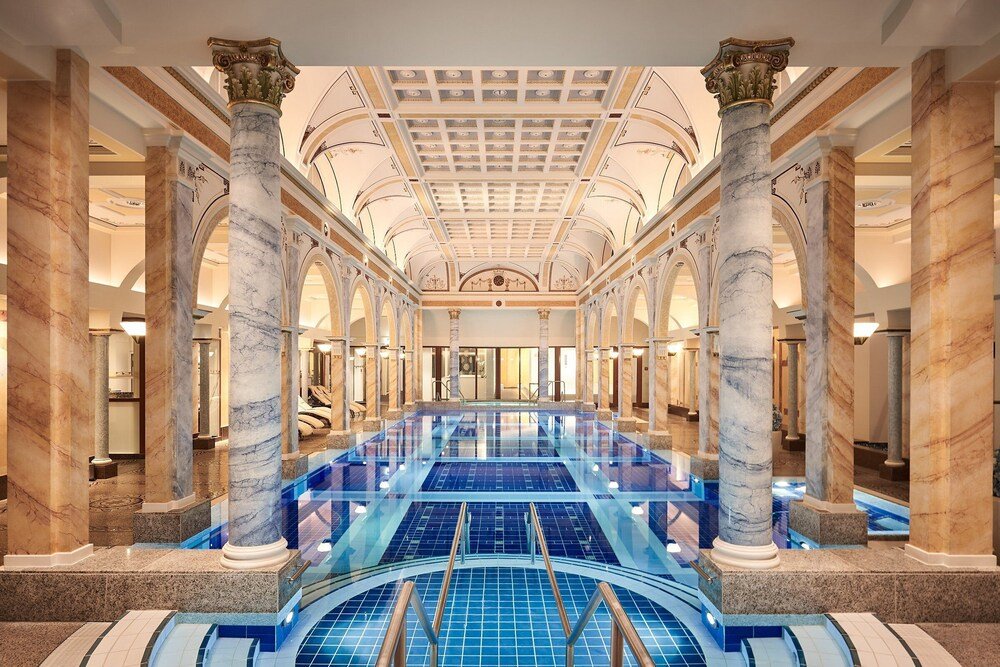 Large indoor swimming pool framed by marble columns