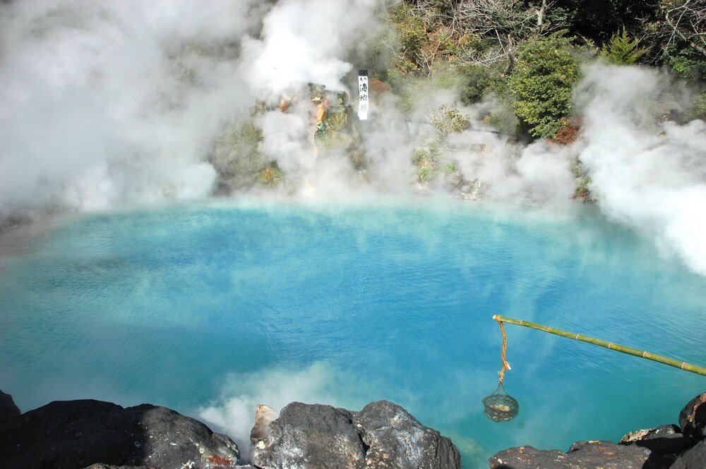Hot spring bath with clear blue water surrounded by rocks