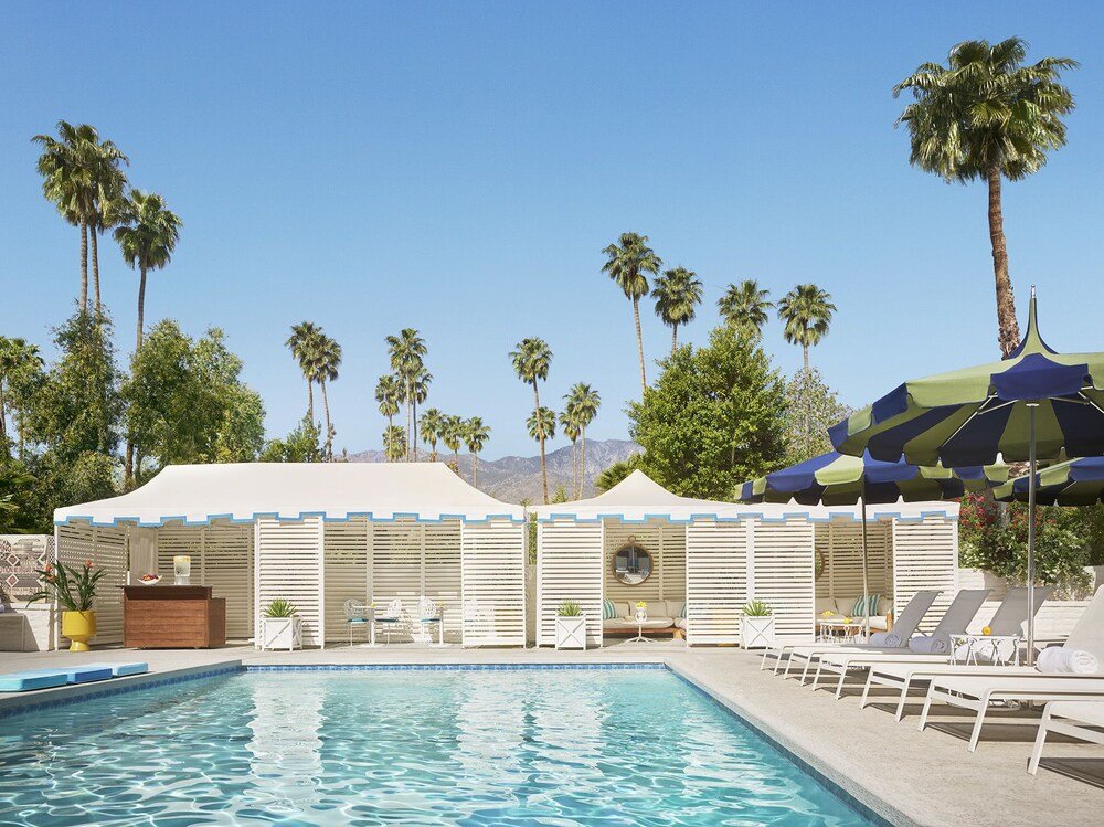 Pool area with lounge chairs and covered seating at the Palm Springs resort